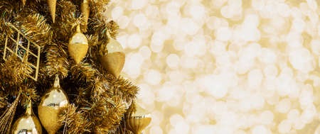 Decorated Christmas tree on Gold Christmas background of de-focused lightsの写真素材