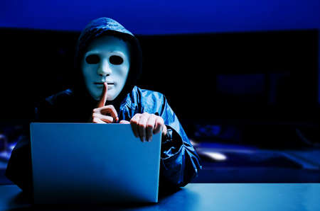 Anonymous computer hacker in white mask and Anonymous computer hacker in white mask and hoodie....