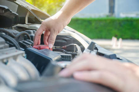 A man checking car engine, Check and maintenance the battery in car with yourself.