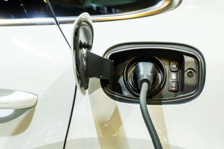Close up of the power supply plugged into an electric car being chargedの写真素材