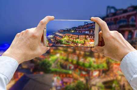 Cropped shot view of man's hands making photo on mobile phone camera is Jiufen Old Street in New Taipei City, Taiwanの写真素材