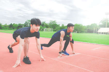 Two sportsman runners on starting position ready for competition in running at the stadium.の写真素材