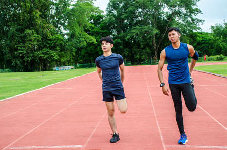 Training teammates. Two male athletes is warming-up,Two runners standing on the racetrack at the...