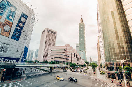 Taipei, Taiwan - May 15, 2019: View of a busy street corner in Downtown Taipei City at rush hour with cars & buses dashing by, Taipei 101 Tower & World Trade Center Building in Xinyi Financial District & people passing on crosswalkのeditorial素材