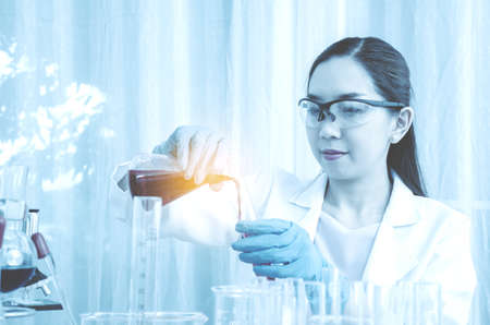 Scientist beautiful woman research and drop medical chemicals sample in test tube at laboratory,...