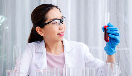 Scientist beautiful woman research and drop medical chemicals sample in test tube at laboratory, Science, chemistry, technology, biology conceptの写真素材