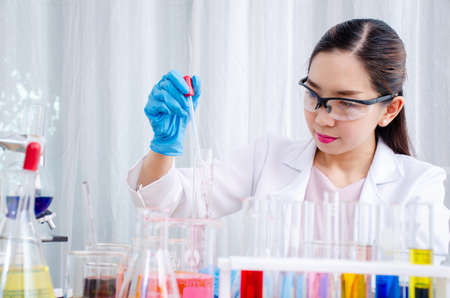 Scientist beautiful woman research and drop medical chemicals sample in test tube at laboratory, Science, chemistry, technology, biology conceptの写真素材