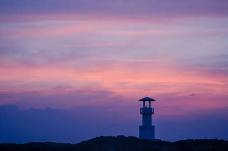 Image of small lighthouse against a tropical ocean sunset and smooth water at Khao Lak Beach in...