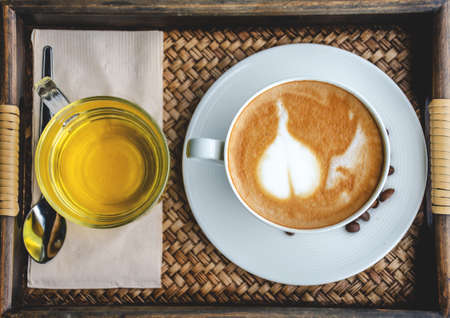 Coffee and tea in the cup on wooden table in cafe. Selective focus.の写真素材