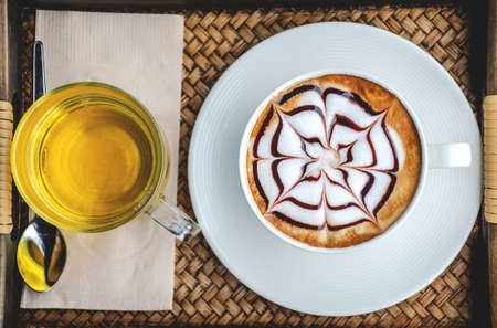 Coffee and tea in the cup on wooden table in cafe. Selective focus.