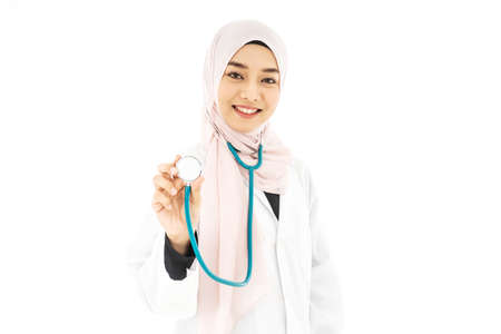 Portrait of muslim asian female Medical doctor showing stethoscope to camera isolated over white backgroundの写真素材
