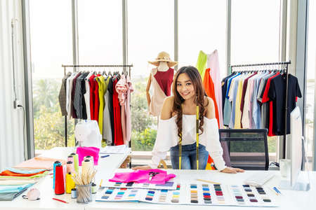 Beautiful young designer woman success business project looking at camera with smile while standing in workshop. Business startup and entrepreneur owner concept.の写真素材