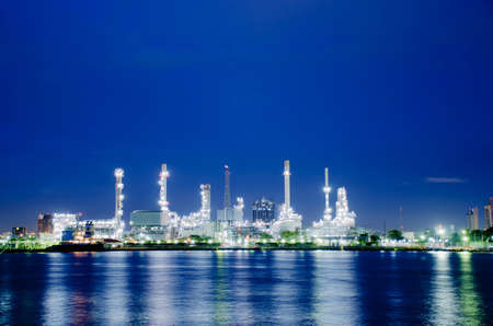 Night scene of oil refinery plant of Petrochemistry industry in twilight time and reflection in near river, gas and oil production processing in Bangkok, Thailand.のeditorial素材