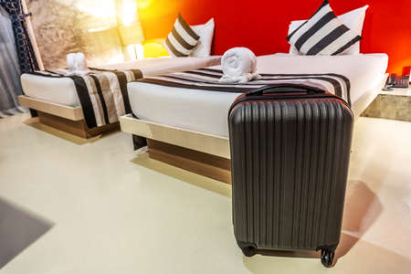 Single black plastic hard shell luggage with extended telescopic handle in the hotel room, One suitcase prepared for business trip. Traveling alone concept. copy space for textの写真素材