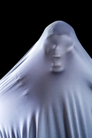 The man is in white clothes and shows a scary looking face  isolated on black background, look like...