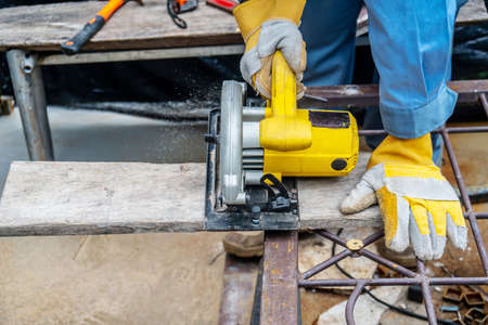 Carpenter using circular saw for cutting wooden boards with power tools, construction and home renovation, repair and construction toolの写真素材