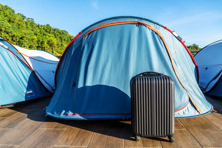 Travel suitcases in camping tent on countryside landscape background - Alternative summer holiday at national park - Road trip and freedom conceptの写真素材