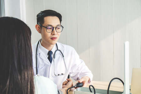 healthcare, hospital and medicine concept - doctor measuring blood pressure from her patient in hospitalの写真素材