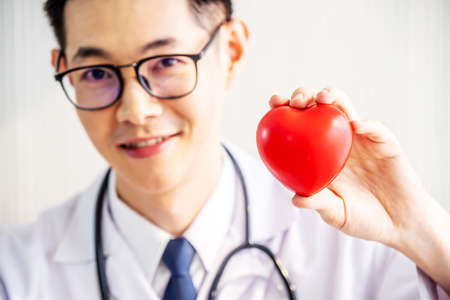 Doctor with stethoscope showing red heart at hospital office, Medical health care and doctor staff service concept.の写真素材
