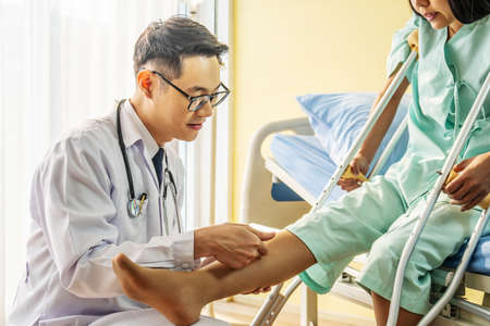 Close-up of Doctor examining female patient with injured leg or knee in clinic, Sport exercise injuries.の写真素材