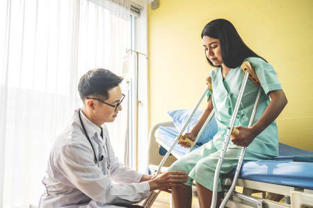 Close-up of Doctor examining female patient with injured leg or knee in clinic, Sport exercise injuries.の写真素材