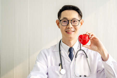 Doctor with stethoscope showing red heart at hospital office, Medical health care and doctor staff service concept.の写真素材