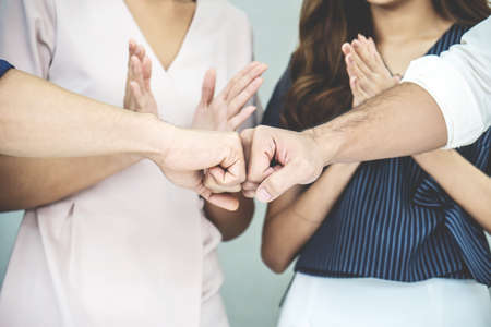 Team of business people negotiating an agreement closing the deal with put fists, Congratulations and Confirmation in the agreement investment together.の写真素材