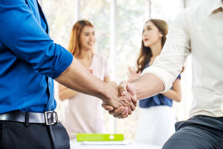 Team of business people negotiating an agreement closing the deal with handshake, Congratulations and Confirmation in the agreement investment together.の写真素材
