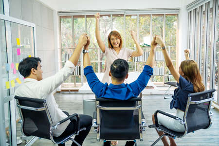 Portrait Of Happy Successful Business Group at office,
Business team celebrating a triumph with arms up, achievement working in office conceptの写真素材