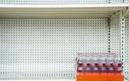 Empty sparkling water shelves in a grocery store or supermarket after fear and panic shopping because of Covid-19, Hoarding food due to Coronavirus outbreak. Food shelf has been wiped out from panic buyingの写真素材