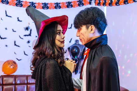 Halloween loving couple vampire in cloak and witch girl looking at each other, view of faces. Halloween or horror themeの写真素材