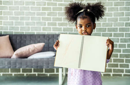 Cute black african american little girl showing self drawn painting,  African people - Childrenの写真素材