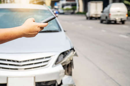 Man using smartphone help calling car mechanic at roadside after traffic accidentの写真素材