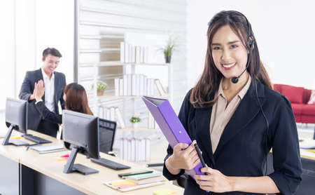 Business customer service asian woman holding file and talking to client in officeの写真素材