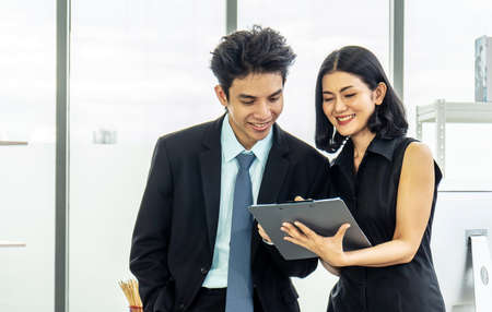 Professional asian business woman holding document file on hand and talk about business plan with business man in the workplace.の写真素材