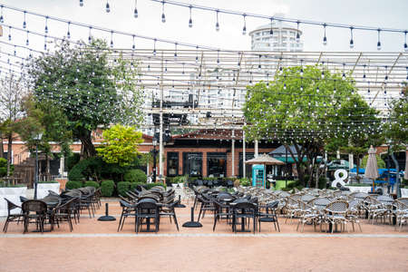 Restaurant table and chairs settings in outdoor dinning area during coronavirus restrictions waiting to reopen.のeditorial素材