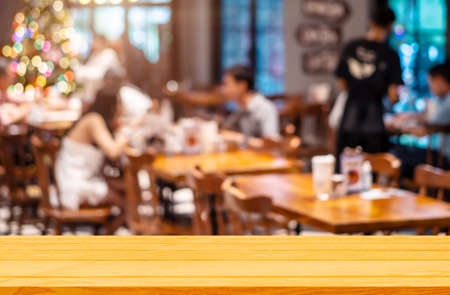 Empty wooden table background of free space for your on blur cafe restaurant in dark background, For...