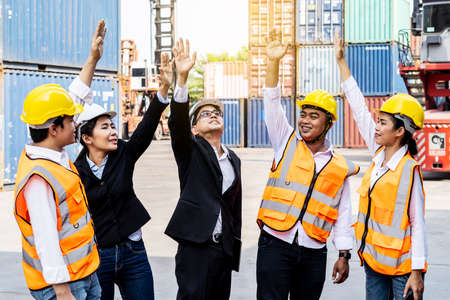Group of employees and management team wearing logistic uniforms for exporting products abroad, stand to put your hands up and raise your hands together for a harmonious work experienceの写真素材