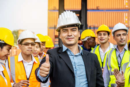 Professional Engineering and worker team congratulated success by applaud their leader after construction project complete and he hold hand with thumb up gestureの写真素材