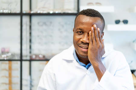 Eyesight And Vision Concept. View of smiling african american attractive optician covering one eye...
