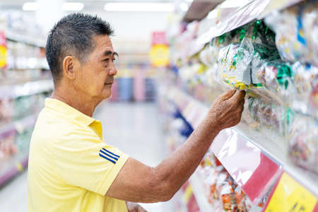 Portrait of man customer choosing and buying food at the supermarketの写真素材