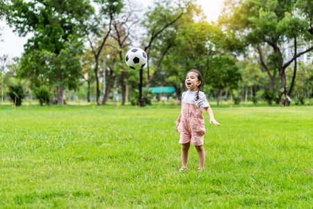 Sports kid. Happy little girl kid kicking a soccer ball, Child playsの写真素材