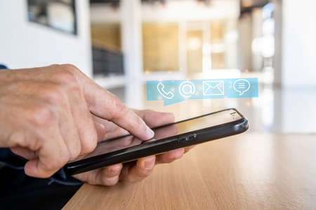Hotline service, Customer support hotline Contact us people connection. Businessman using Smart Phone with the email, call phone, address, Chat message iconsの写真素材