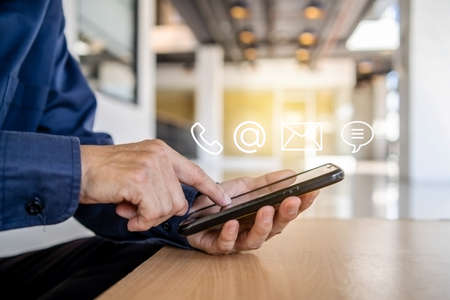 Hotline service, Customer support hotline Contact us people connection. Businessman using Smart Phone with the email, call phone, address, Chat message iconsの写真素材