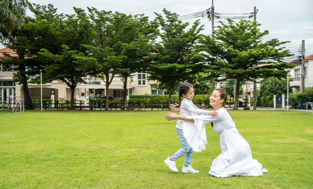 Family fun in the park. The girl runs to her mother, her mother opened her arms for hugsの写真素材