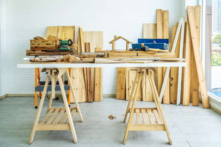 Background image of carpenters workstation, carpenters work table with different tools and wood cutting stand with wood shavingsの写真素材