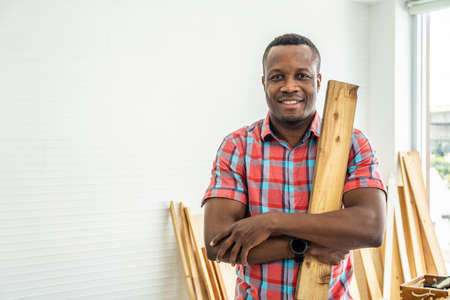 Portrait african american happy male woodworker or carpenter smiling, wearing shirt crossing arms...