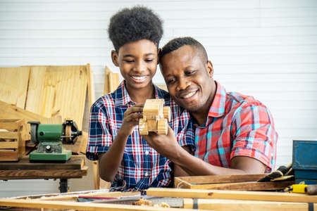 Happy family african american father and son carpenter gather craft a car out of wood and play, family concept to stay at home and enjoy good relationship hobby together craftsman or carpenterの写真素材