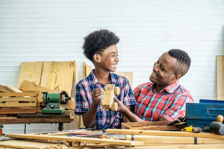 Happy family african american father and son carpenter gather craft a car out of wood and play, family concept to stay at home and enjoy good relationship hobby together craftsman or carpenterの写真素材