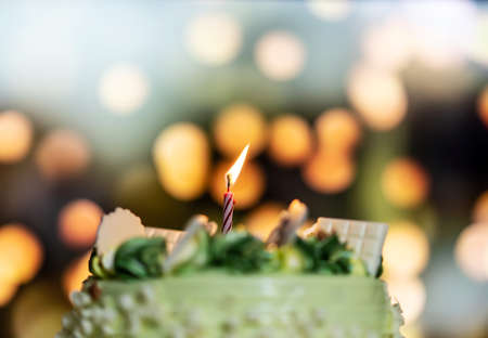 Happy birthday cake with candles on the background of bright lights bokeh.の写真素材